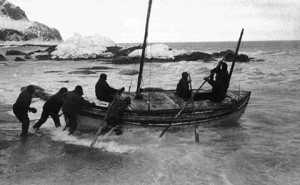 Shackleton and crew launch the lifeboat, James Caird, at the start of their journey to South Georgia.  Photo taken by expedition photographer, Frank Hurley, April 1916.